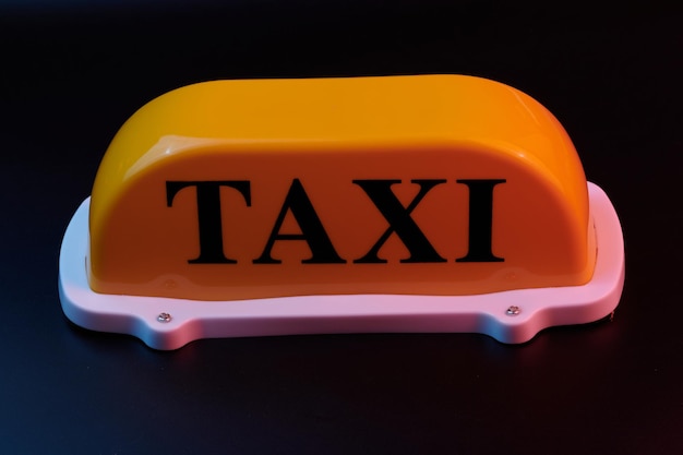 Żółty znak taksówki na dach samochodu odizolowany na czarnym tle