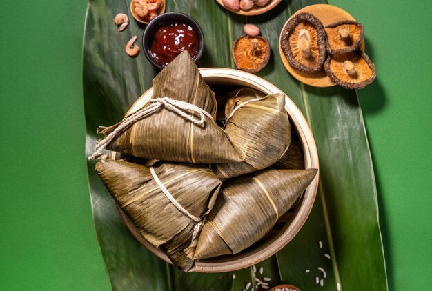 Zongzi gotowane na parze pierogi ryżowe na tle zielonego stołu jedzenie w festiwalu smoczych łodzi duanwu koncepcja bliska kopia przestrzeń widok z góry płasko leżał