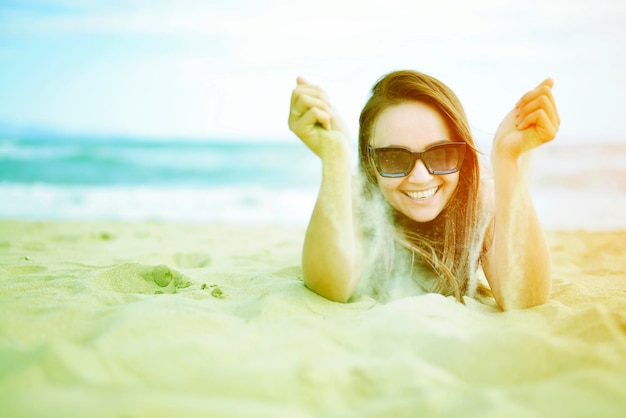 Zdjęcie zrelaksowana i pozytywna kobieta leżąca na stonowanym piaskowym zdjęciu