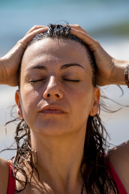 Zdjęcie zrelaksowana kobieta dotykająca włosów wellness letnie wakacje na tropikalnej karaibskiej plaży wysokiej jakości