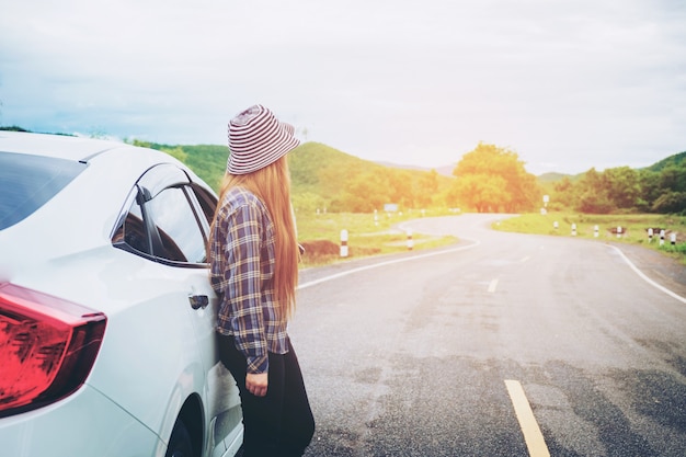 Zrelaksowany szczęśliwy kobieta podróżnik na lato roadtrip wakacje na hatchback samochodzie