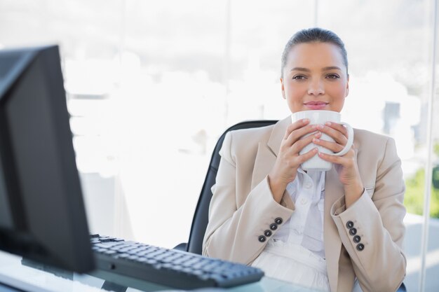 Zrelaksowany wyrafinowany bizneswoman zapachu kawy