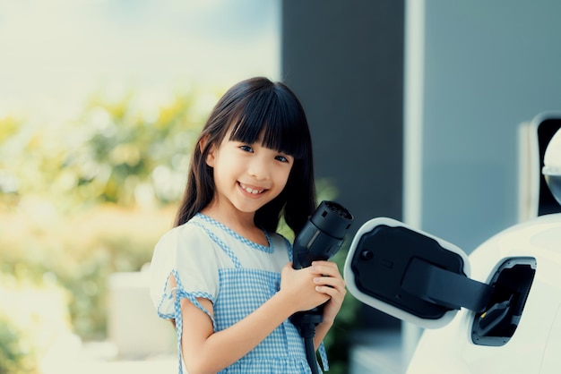 Zrównoważone źródło zasilania dla progresywnego stylu życia pokazane przez dziewczynę trzymającą wtyczkę EV