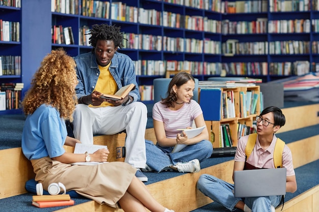 Zróżnicowana grupa studentów w salonie bibliotecznym z żywymi niebieskimi kolorami kopii przestrzeni