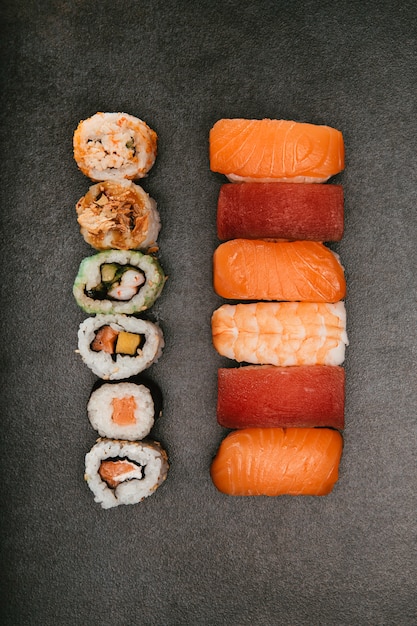 zróżnicowane japońskie sushi o różnych smakach na czarnym tle