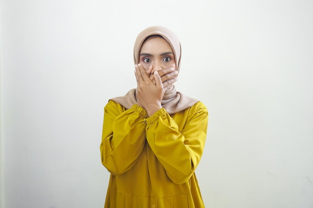 Zszokowana azjatycka muzułmanka zakrywająca usta ręką za pomyłkę odizolowaną na białym tle