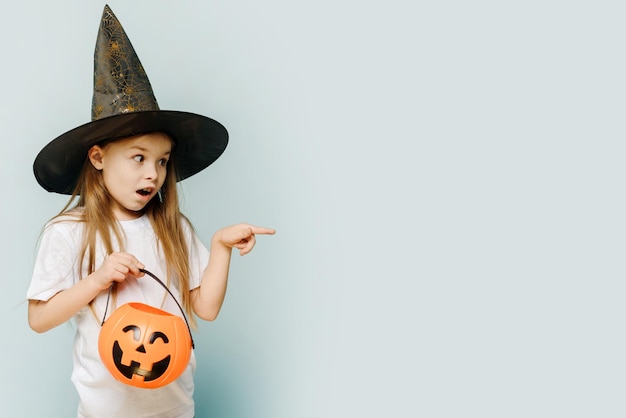 Zszokowana mała dziewczynka w kostiumie na halloween pokazuje na przestrzeni reklamowej kopii