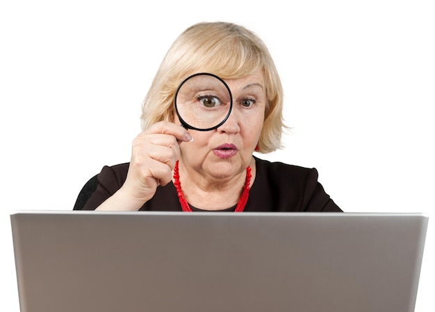 Zszokowana Stara Kobieta Patrząca Przez Lupę I Używająca Laptopa - Na Białym Tle