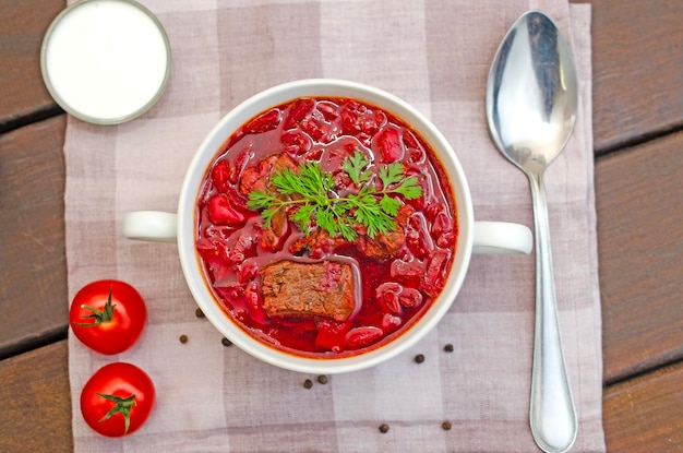 Zdjęcie zupa borszowa z warzywami i mięsem na drewnianym stole