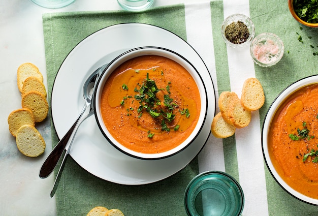 Zupa krem z czerwonej soczewicy z pomidorami na stole. zdrowe wegańskie ocieplające jedzenie dla całej rodziny
