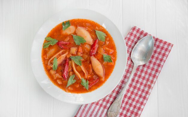 Zupa Minestrone Z Makaronem I Ziołami. Włoskie Jedzenie. Gorące Posiłki. Danie Wegetariańskie. Stół Do Jadalni. Białe Tło Drewna. Zbliżenie.