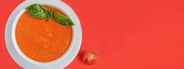 Zupa pomidorowa w białej misce na czerwonym tle Widok z góry Skopiuj miejsce
