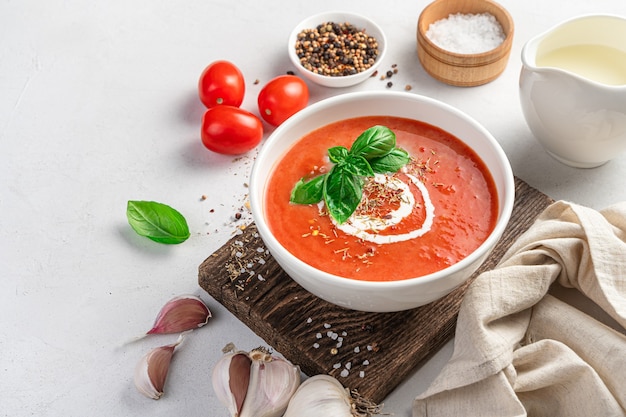 Zupa pomidorowa z bazylią i śmietaną na szarym tle zupa jarzynowa jedzenie wegetariańskie