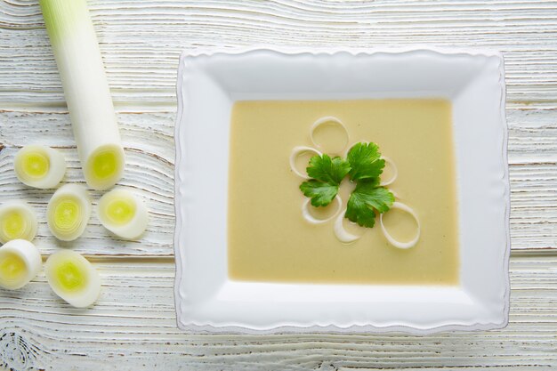 zupa vichyssoise z porów na białym drewnie