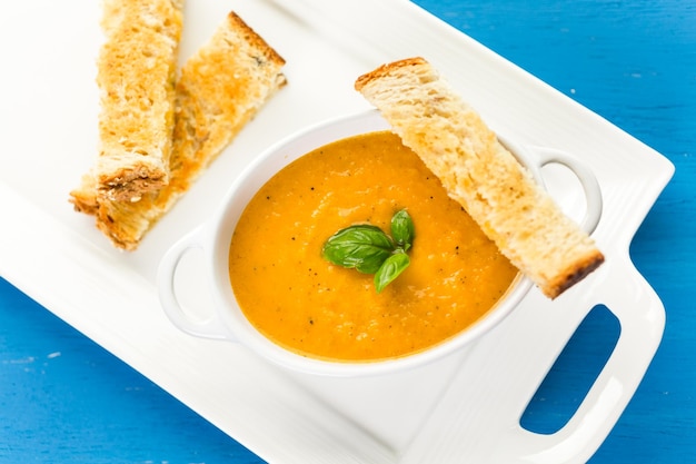 Zupa z pieczonych pomidorów gotowana z ekologicznymi pomidorami rodzinnymi i podawana z grillowaną kanapką z serem.