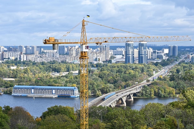 Żuraw budowlany na tle budynków mieszkalnych i Dniepru