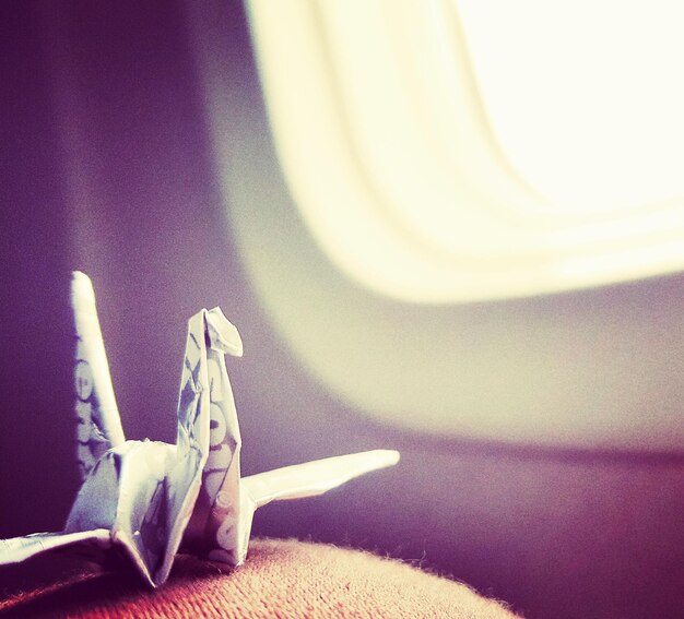 Zdjęcie Żuraw papierowy przy oknie samolotu