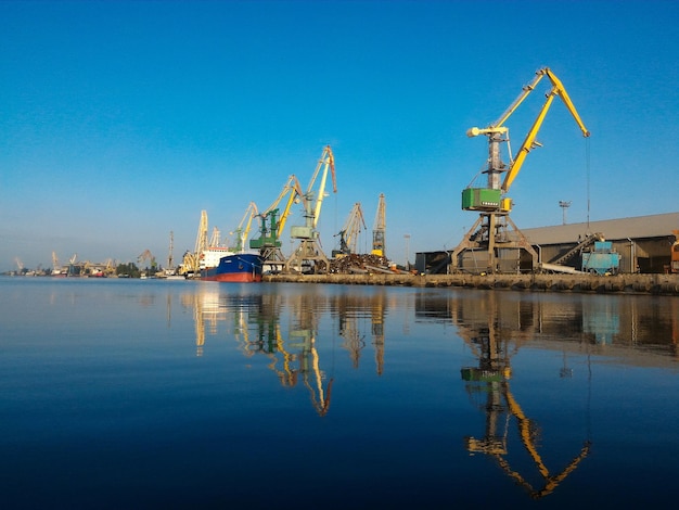 Zdjęcie Żurawie w porcie na tle jasnego niebieskiego nieba panoramiczny widok na port