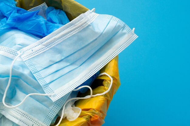 Zużyte maski zakaźne i rękawice medyczne do kosza na śmieci