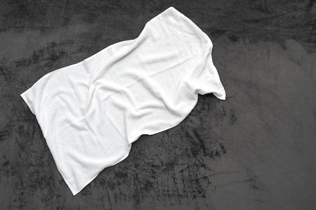 Zużyty biały ręcznik na łóżku w pokoju hotelowym