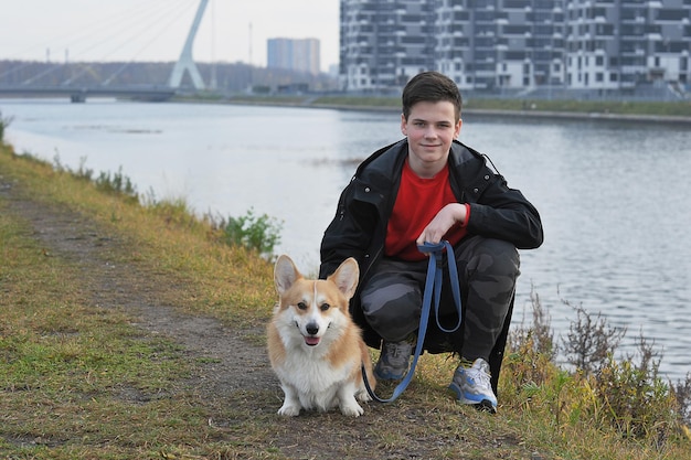 Zwierzak Na Spacerze - Welsh Corgi Pembroke Rudowłosy Z żółtym Ubarwieniem I Chłopcem