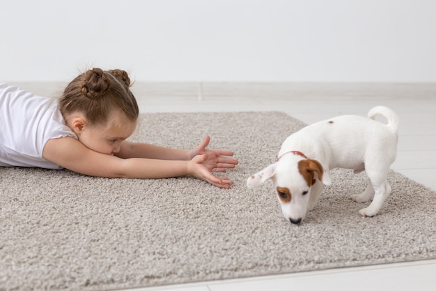Zdjęcie zwierzęta domowe i koncepcja zwierząt - dziewczynka bawi się ze szczeniakiem jack russell terrier