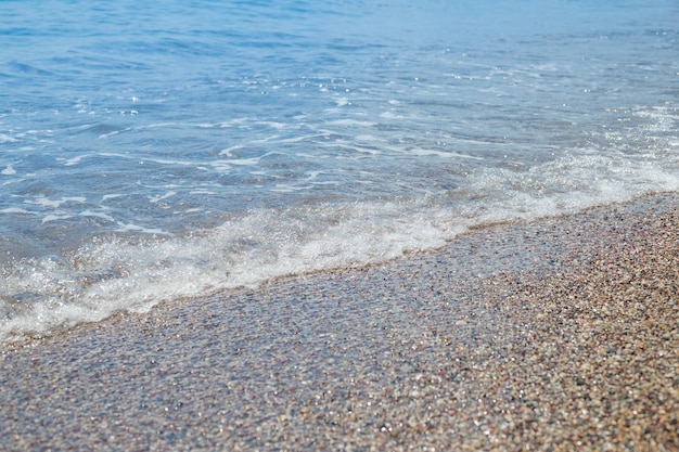 Żwirowa plaża z lazurową morską wodą tekstury tłaCzysta woda morska na kamienistej plaży czysta woda na kamiennym brzegulinia brzegowa z ukamienowanym brzegiemprzepiękny krajobraz morskiwakacje do letniego raju