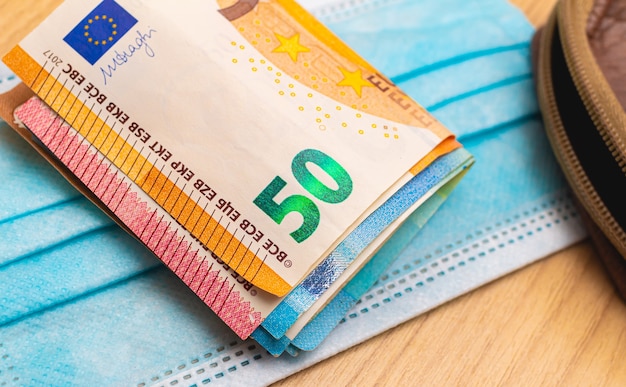 zwitek banknotów euro na niebieskiej masce chirurgicznej dla koncepcji gospodarki podczas pandemii chrząszczy