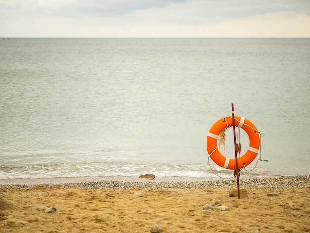 Życie pomarańczowe pierścień na plaży z widokiem na morze kopiować przestrzeń