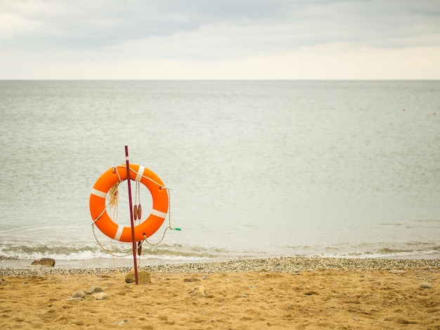 Życie pomarańczowe pierścień na plaży z widokiem na morze kopiować przestrzeń