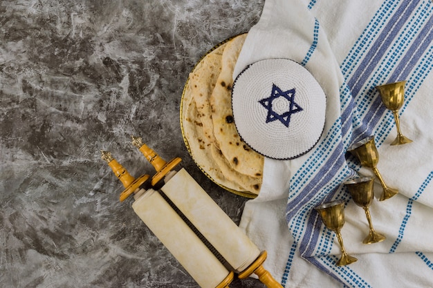 Żydowskie obchody święta symboli ze świętą księgą religijną w zwoju Tory, izraelskim chlebem z macy Pesach i czterema filiżankami wina