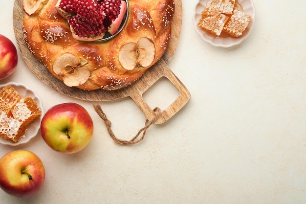 Żydowskie święta Rosh Hashanah lub Rosh Hashana Pomegranaty jabłka miód i okrągła challah na wiejskim szarym tle tabeli żydowskie święto jesieni Shana Tova Yom kippur koncepcja Górny widok