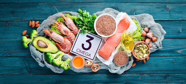 Żywność Zawierająca Kwasy Omega 3. Witamina Zdrowa żywność: Awokado, Ryby, Krewetki, Brokuły, Len, Orzechy, Jajka, Pietruszka. Widok Z Góry. Wolne Miejsce Na Twój Tekst. Na Niebieskim Tle Drewnianych.