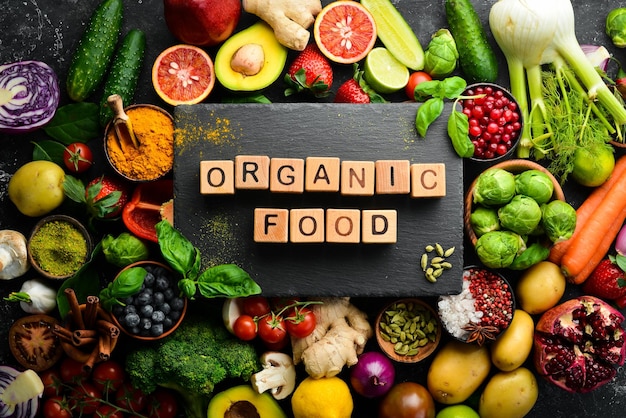 Żywność. Zestaw świeżych warzyw i owoców na czarnym tle kamienia. Jedzenie organiczne. Widok z góry. Wolne miejsce na Twój tekst.