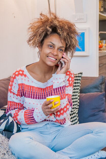 Żywy piękna młoda kobieta afroamerykanów z afro fryzurę na jej telefon komórkowy słuchanie rozmowy z szerokim promieniach uśmiechu rozkoszy