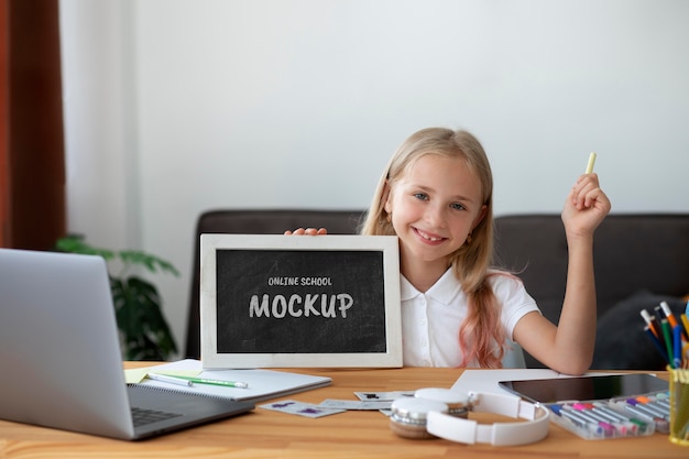 Young girl using small blackboard for online courses