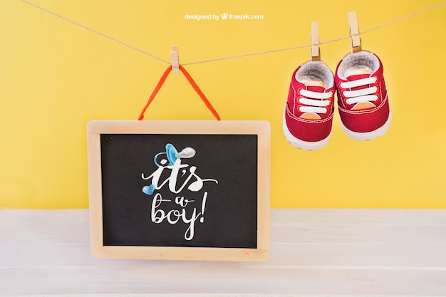 Gratis PSD baby mockup met schoenen op klerenpin