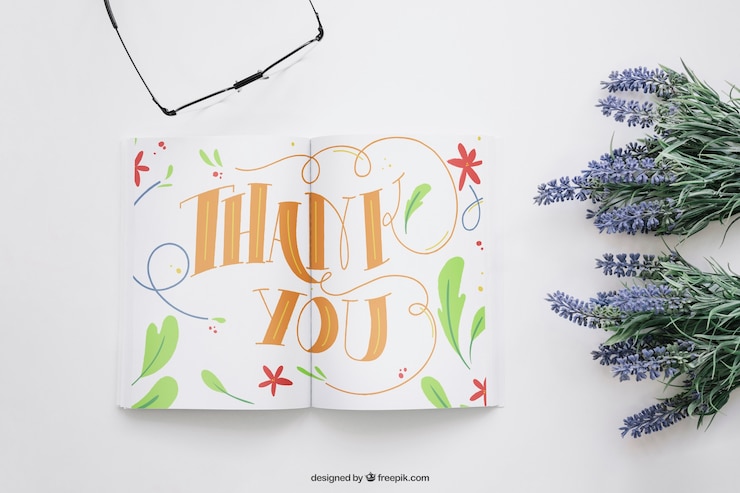 Gratis PSD boekmockup met bloemen en glazen