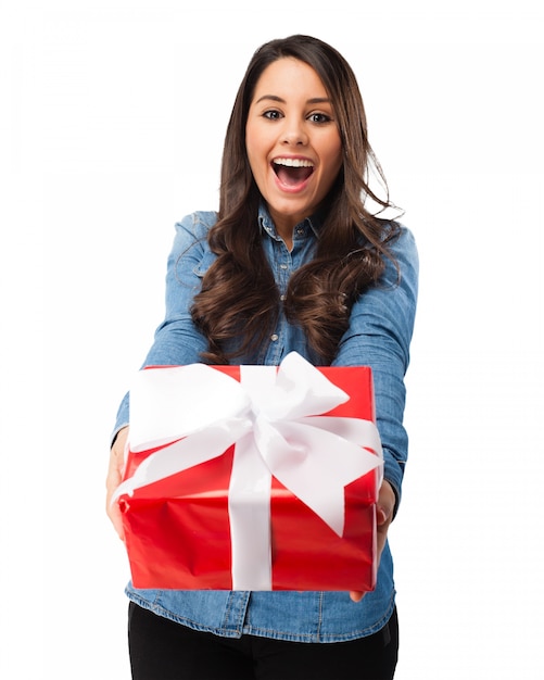 Chica emocionada sujetando un regalo con un lazo blanco