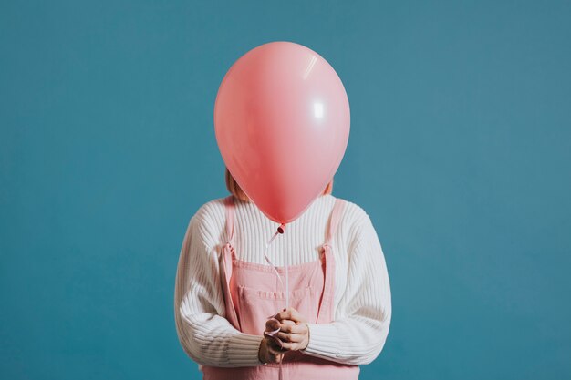 Chica con un globo de helio rosa.