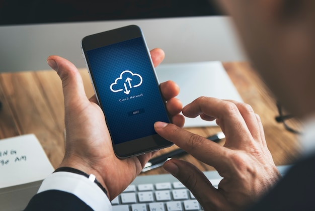 Close-up van zakenman die smartphone met wolk gegevensverwerkingssymbool gebruiken