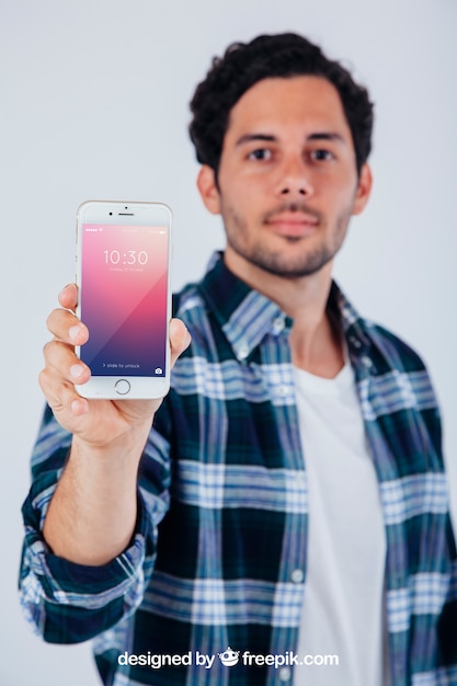 PSD gratuito diseño de mock up con chico joven sosteniendo smartphone