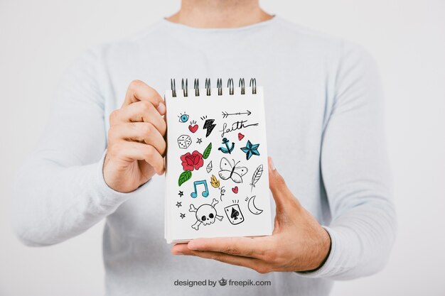Diseño de mock up con manos sosteniendo libreta