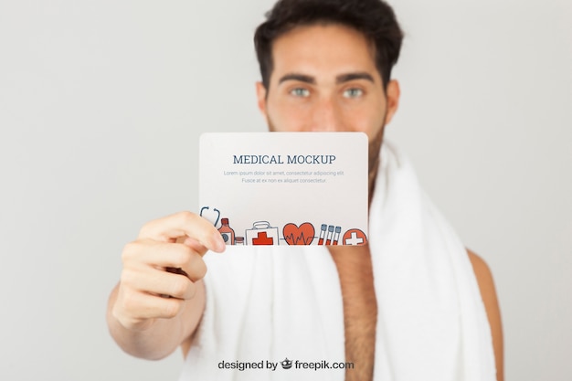 PSD gratuito diseño de mock up médico con hombre joven sujetando tarjeta