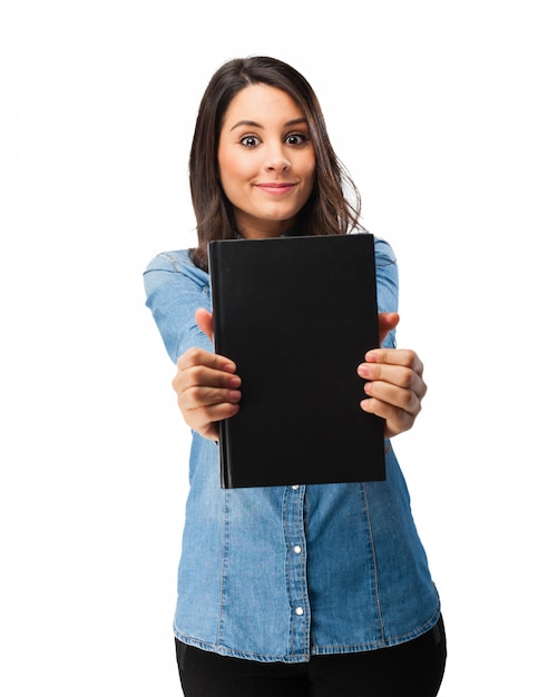 Estudiante alegre mostrando su libro con la cubierta negra