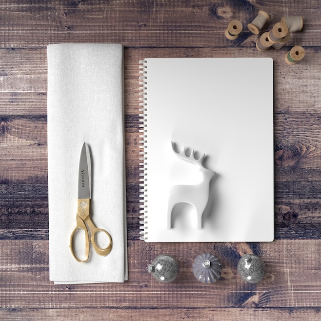 Forbici e carta per fare una decorazione di renne sul tavolo di legno