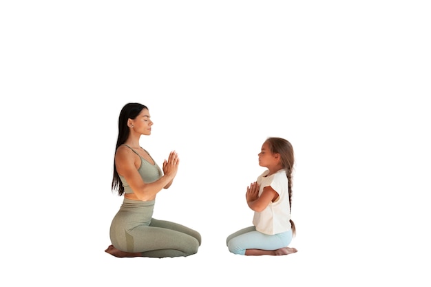 Instructora de yoga femenina haciendo meditación con niña