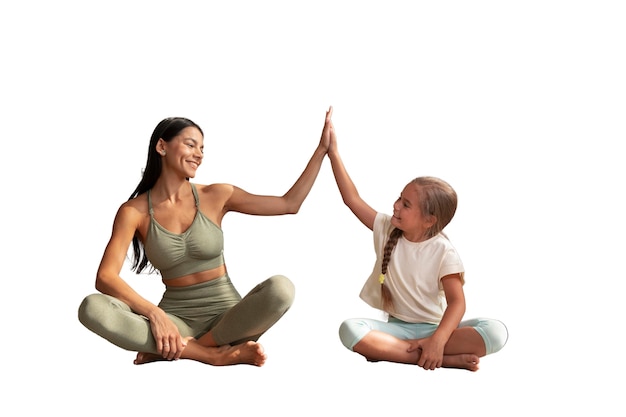 Instructora de yoga femenina haciendo meditación con niña