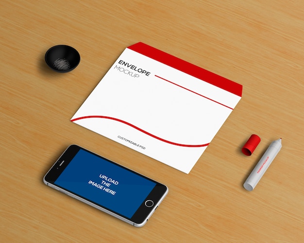 Kantoorbehoeftenconcept met envelop en smartphonemodel