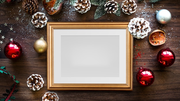 Klassiek gouden frame mockup met kerstversiering op houten achtergrond